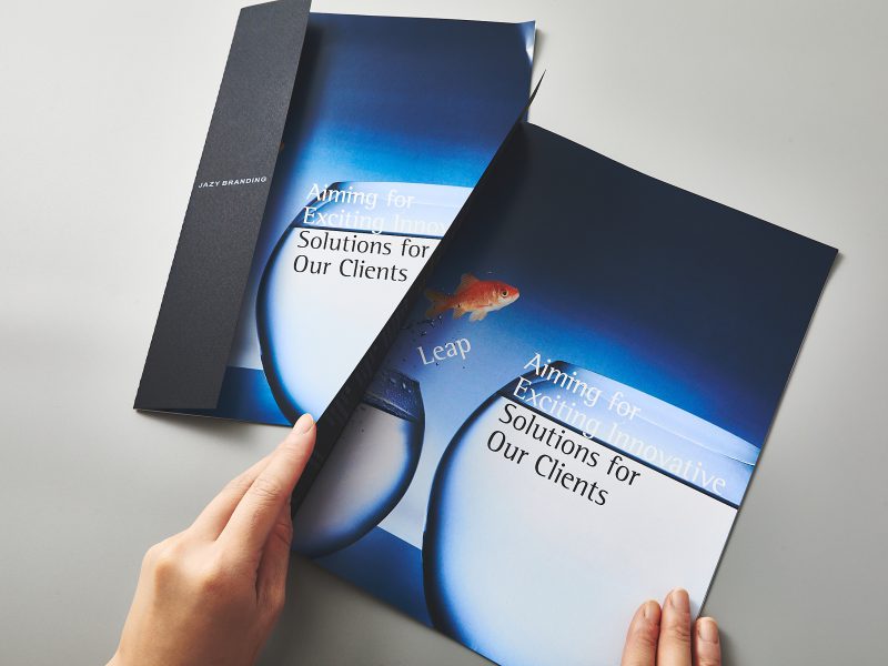 会社案内パンフレット・表紙を開いている場面